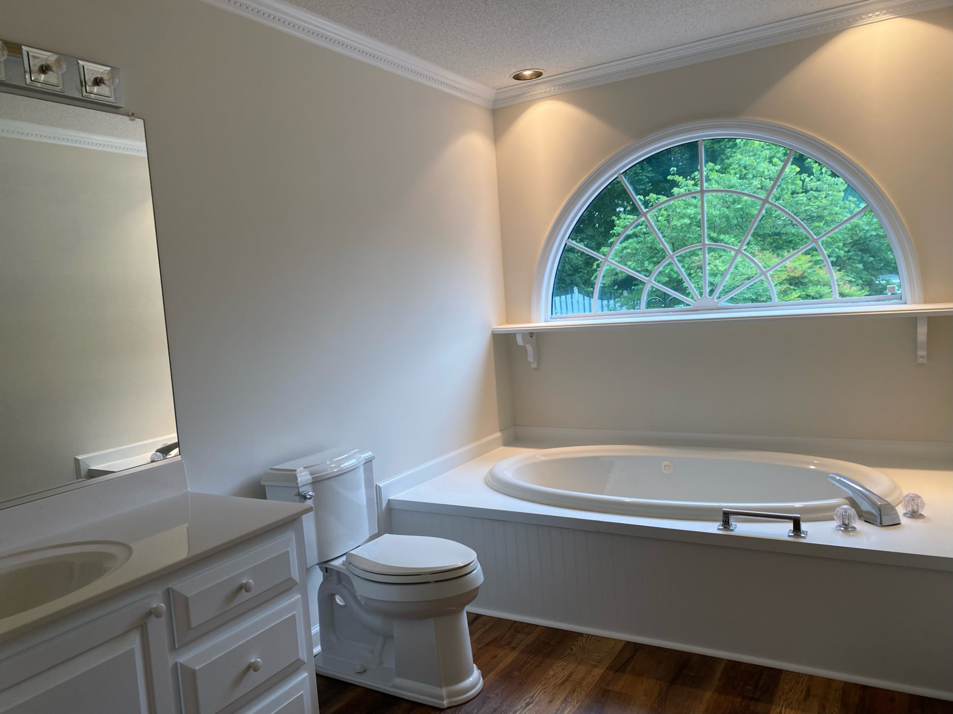 Freshly painted bathroom with garden tub, arched window, and updated trim in Charlotte, NC