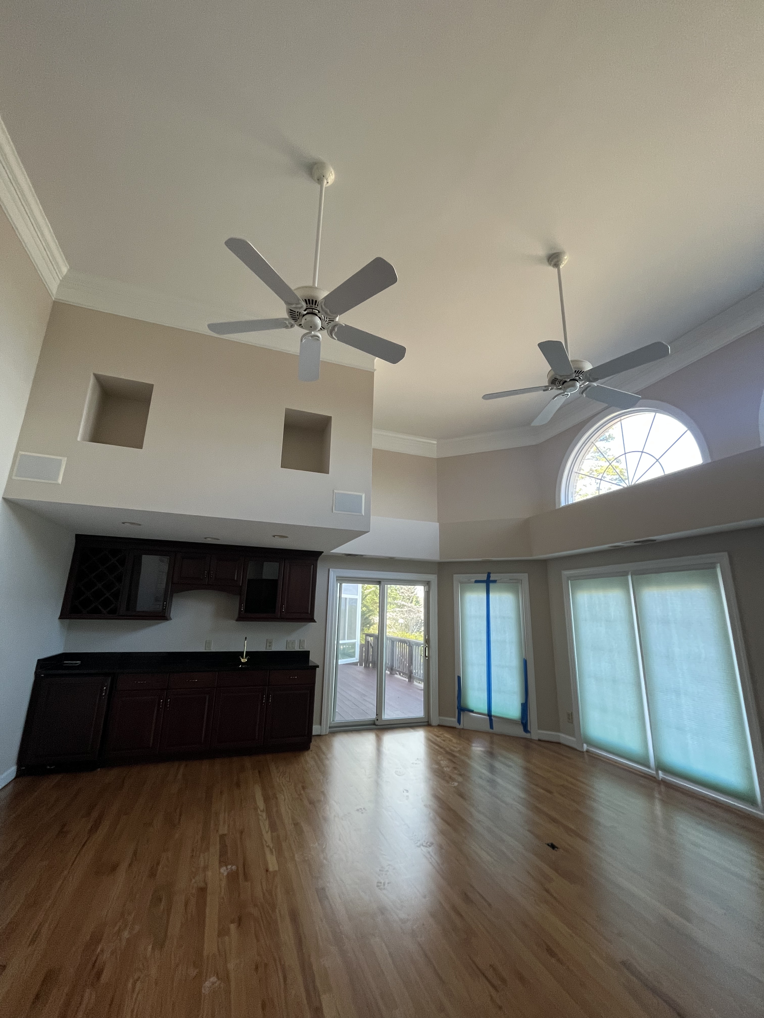 Spacious vaulted living room with fresh paint, ceiling fans, and natural light in Charlotte, NC