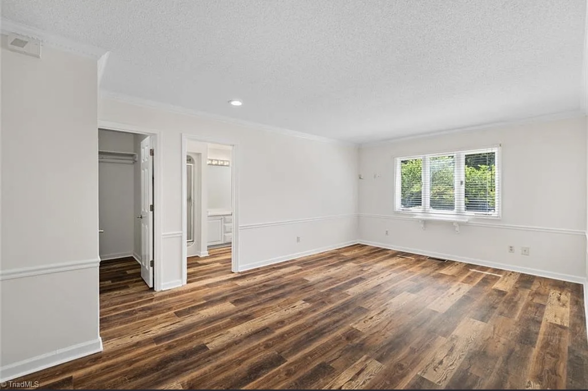Freshly painted bedroom with new LVP flooring and trim