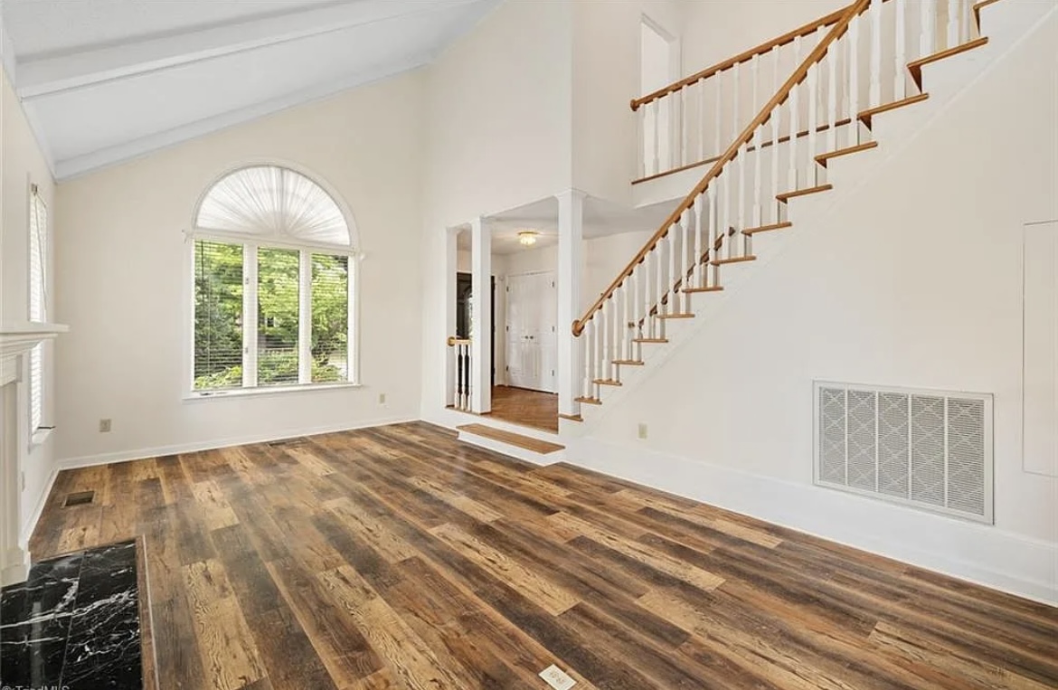 Repainted two-story great room with stairway and new flooring